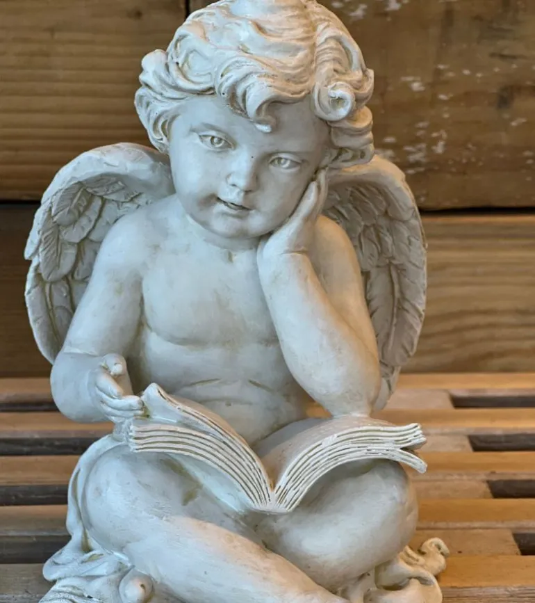 Gravpynt, engel siddende med bog.
